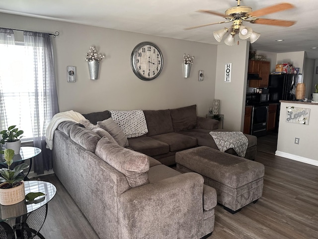 living area featuring ceiling fan, dark wood-type flooring, and baseboards