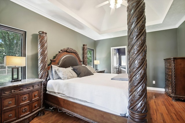 bedroom featuring ornamental molding, hardwood / wood-style floors, and a tray ceiling