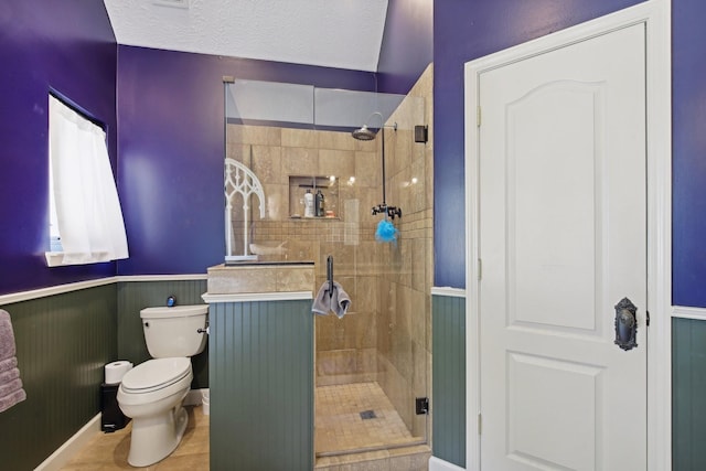 bathroom featuring tile patterned flooring, toilet, a textured ceiling, and walk in shower