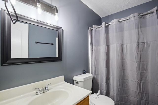 bathroom with a shower with curtain, vanity, a textured ceiling, and toilet