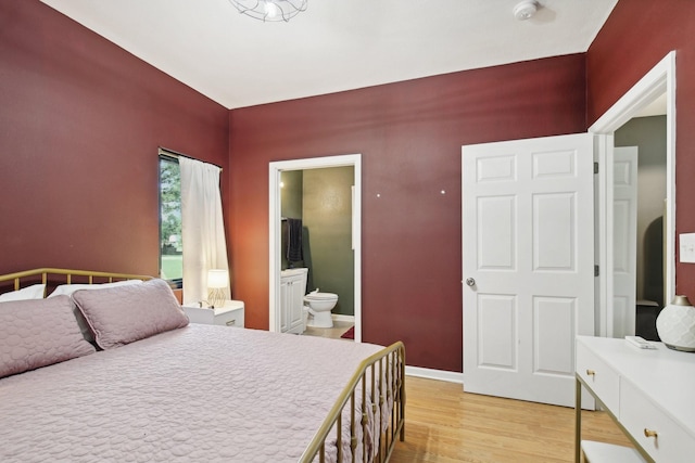 bedroom with connected bathroom and light wood-type flooring