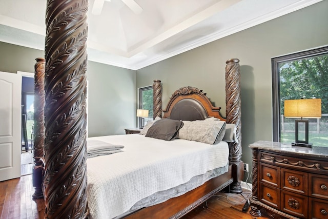 bedroom with ornamental molding, ceiling fan, dark hardwood / wood-style flooring, and a tray ceiling