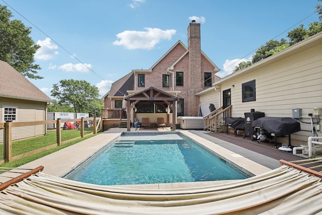 view of swimming pool featuring a wooden deck, a gazebo, and a patio area