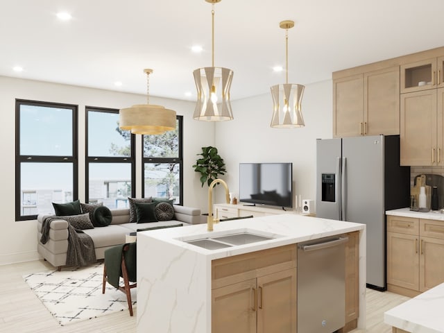 kitchen with a center island with sink, sink, hanging light fixtures, light brown cabinets, and stainless steel appliances