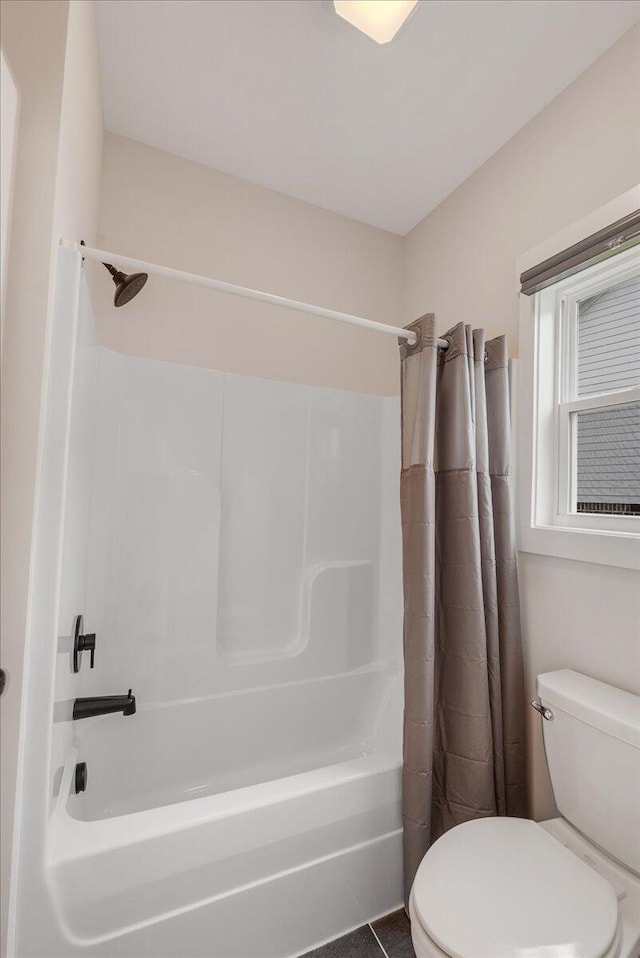 bathroom with shower / bath combination with curtain and toilet