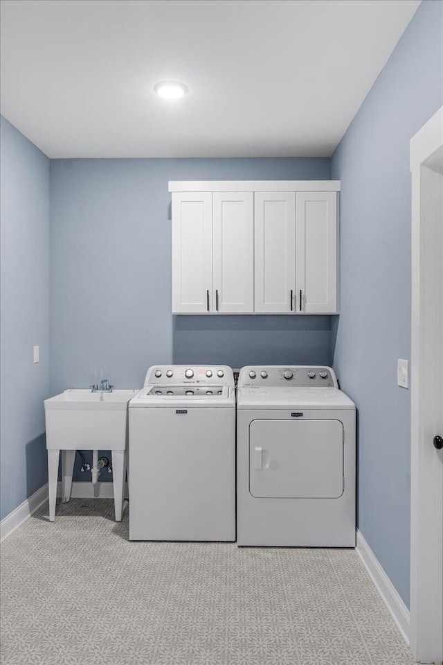 washroom with separate washer and dryer, sink, and cabinets