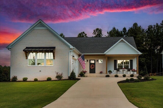 view of front of property with a lawn and a porch