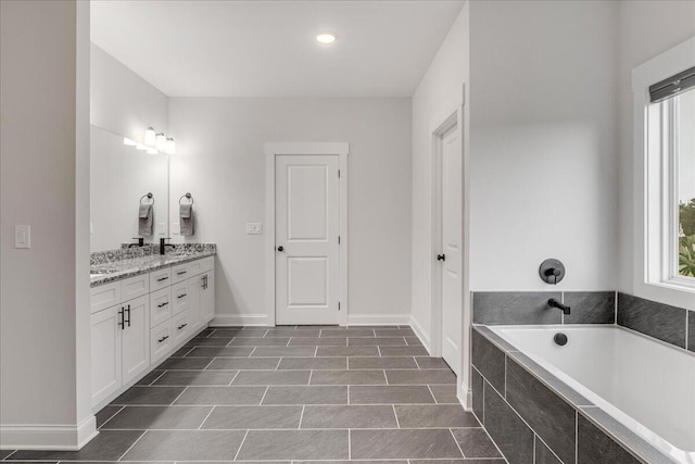 bathroom featuring vanity and a relaxing tiled tub