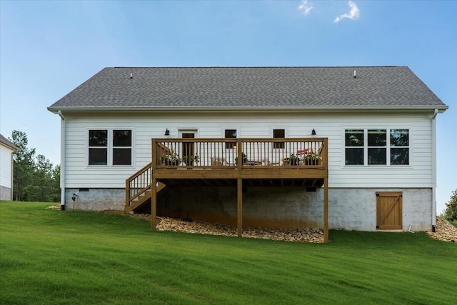 back of property featuring a wooden deck and a yard