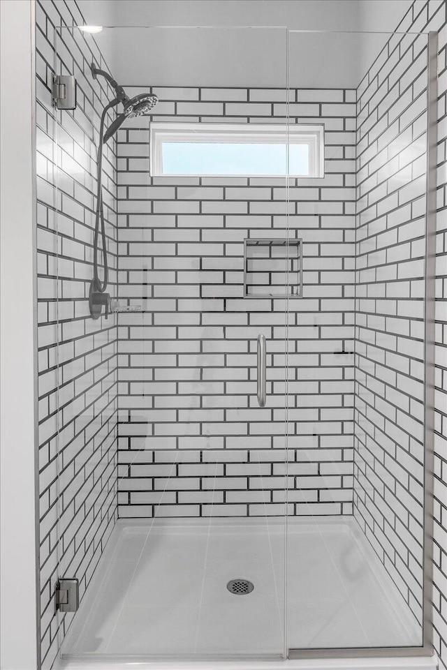 bathroom with a shower with door