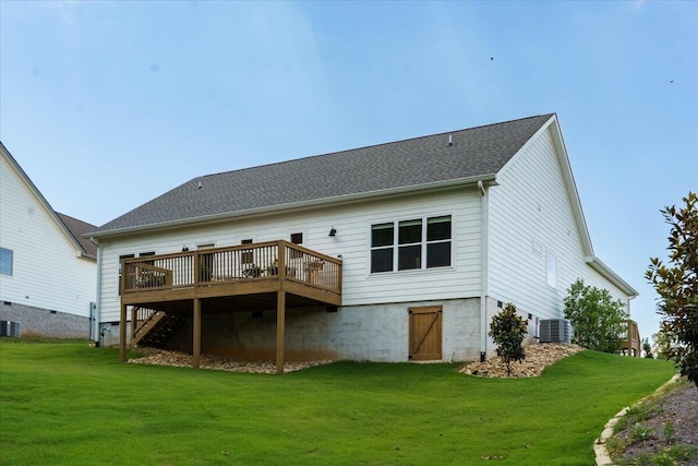 back of house featuring a wooden deck, cooling unit, and a lawn