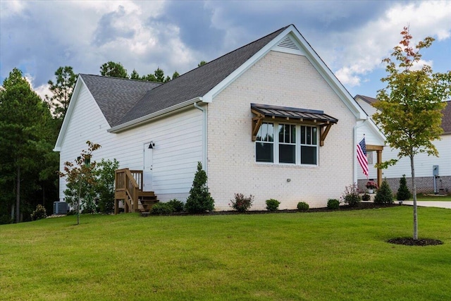 view of side of home with central AC and a lawn