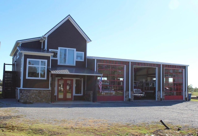exterior space with a standing seam roof, french doors, metal roof, and stone siding