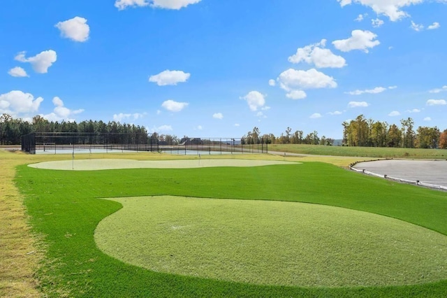 view of community featuring view of golf course, a water view, and fence