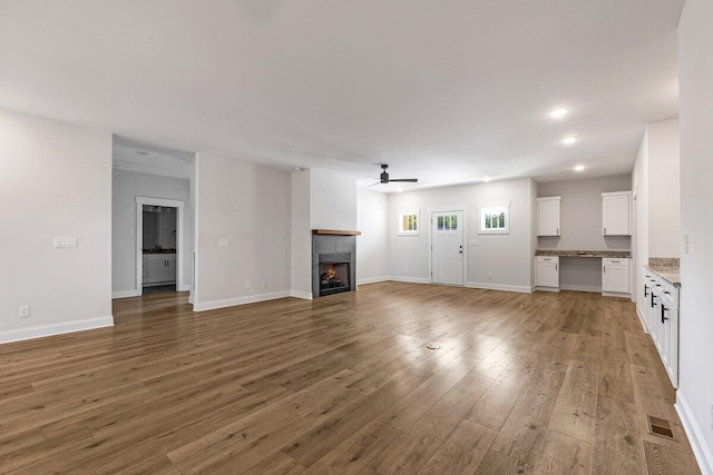 unfurnished living room with hardwood / wood-style flooring and ceiling fan