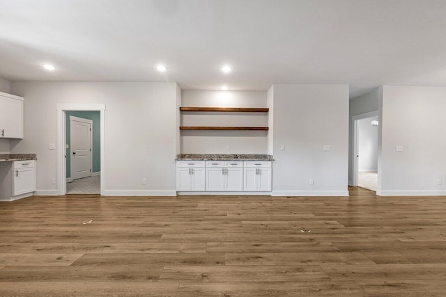 unfurnished living room with light wood-style floors, recessed lighting, and baseboards