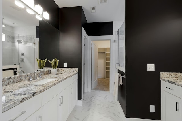 bathroom featuring a shower with door and vanity