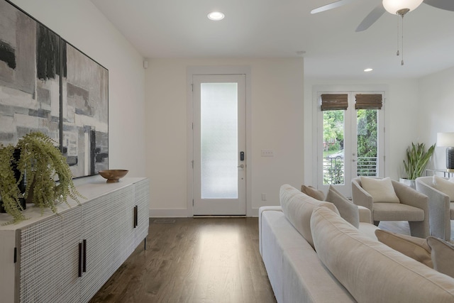 living room featuring dark wood-type flooring and ceiling fan