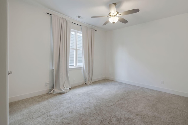 spare room with ceiling fan and light colored carpet