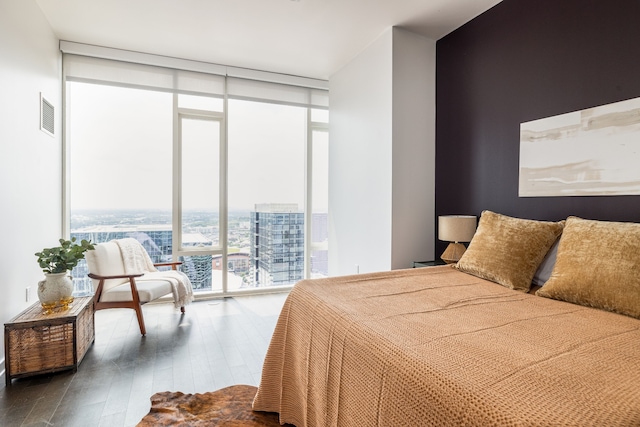 bedroom with wood-type flooring and a wall of windows