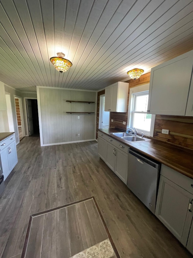 kitchen with sink, dishwasher, butcher block countertops, and white cabinets