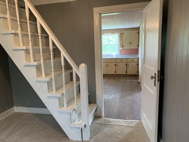 stairs featuring sink and carpet