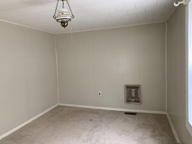 empty room featuring crown molding, carpet flooring, and heating unit