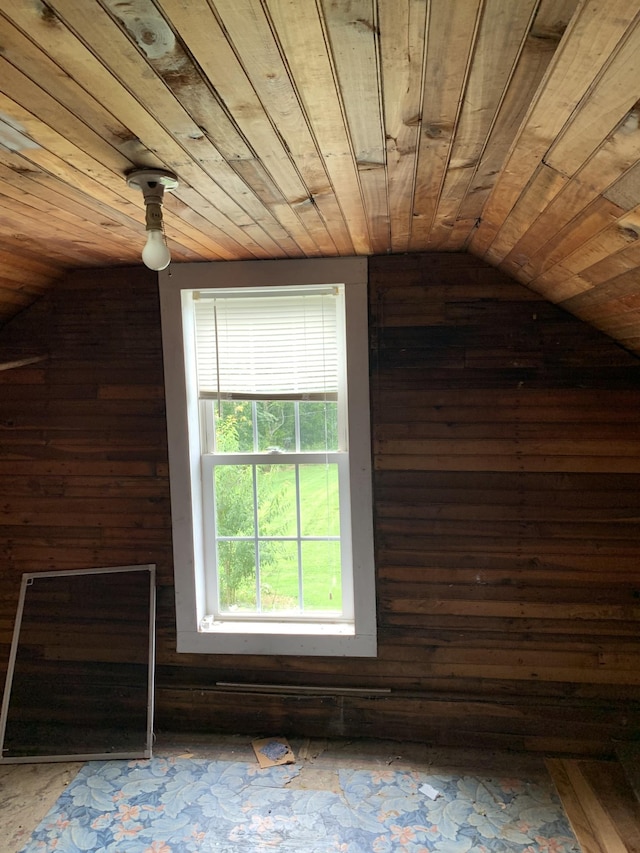 additional living space featuring lofted ceiling, wooden ceiling, and wood walls