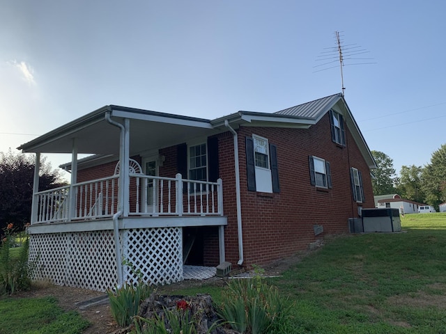 view of side of property with a porch and a lawn