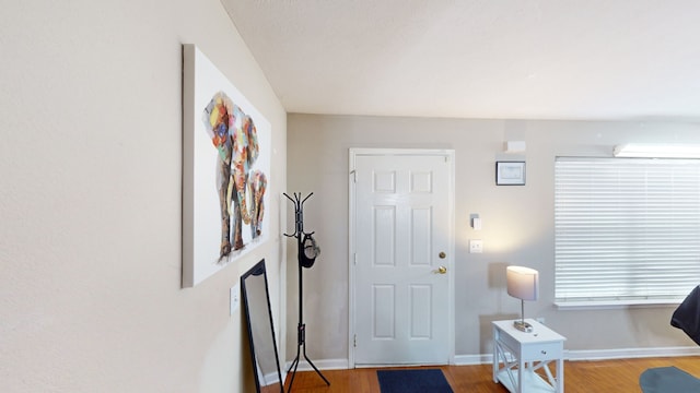 entryway with an AC wall unit and hardwood / wood-style flooring