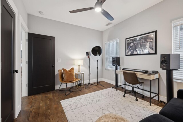 home office with dark wood-type flooring and ceiling fan