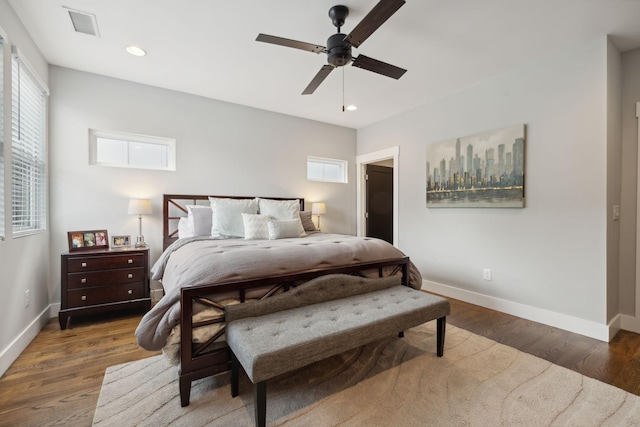 bedroom featuring multiple windows, dark wood-type flooring, and ceiling fan