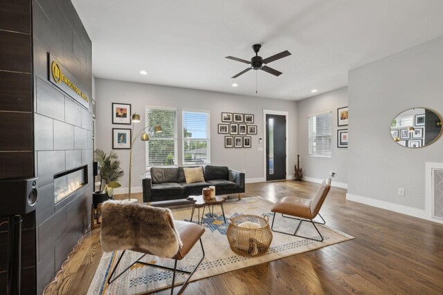 living room featuring a fireplace, dark hardwood / wood-style floors, and ceiling fan