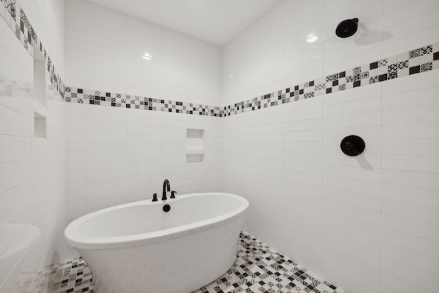 bathroom featuring tile patterned flooring, tile walls, and a tub