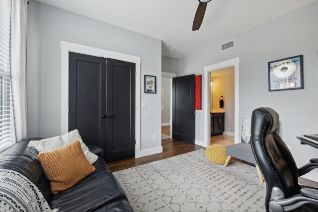 home office with dark hardwood / wood-style flooring and ceiling fan