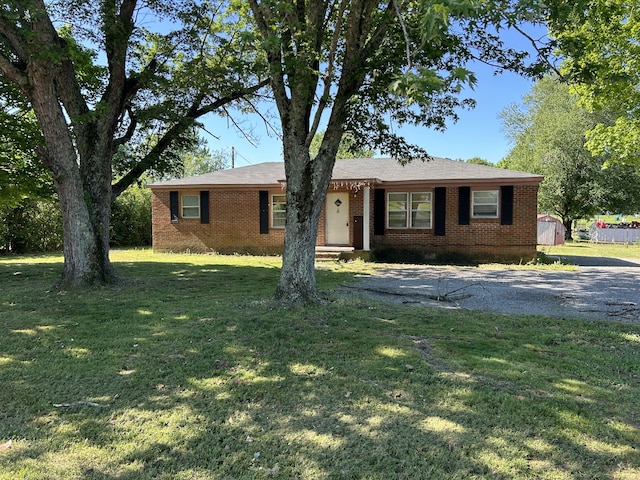 ranch-style house with an outdoor structure and a front lawn