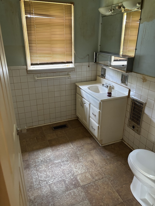 bathroom featuring backsplash, vanity, tile patterned floors, tile walls, and toilet