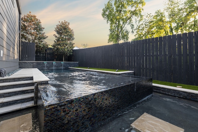 exterior space featuring pool water feature and a fenced in pool