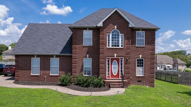 colonial-style house featuring a front yard