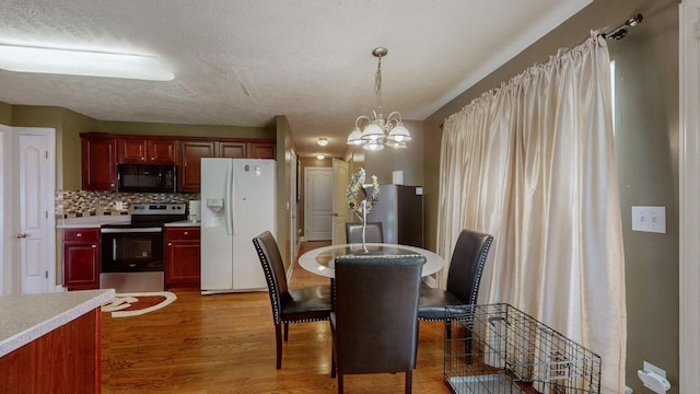 dining area with an inviting chandelier, dark hardwood / wood-style floors, and a textured ceiling