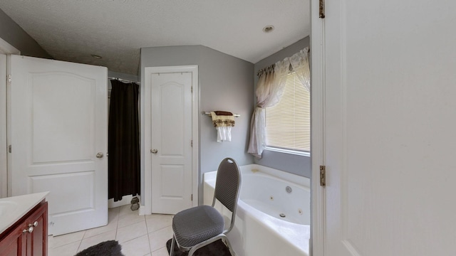 bathroom with vanity, tile patterned flooring, a tub, and a textured ceiling