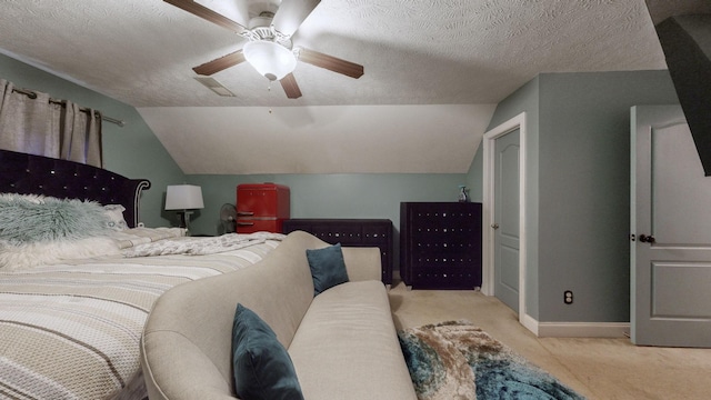 bedroom featuring light carpet, ceiling fan, lofted ceiling, and a textured ceiling