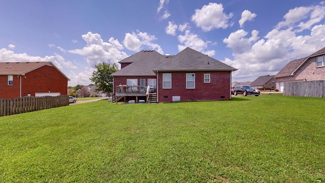 rear view of property featuring a yard and a deck