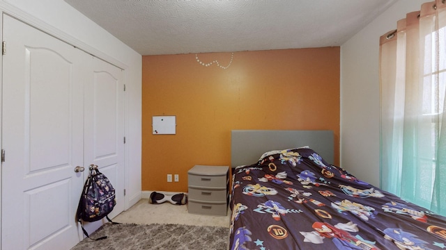 bedroom with light carpet and a textured ceiling