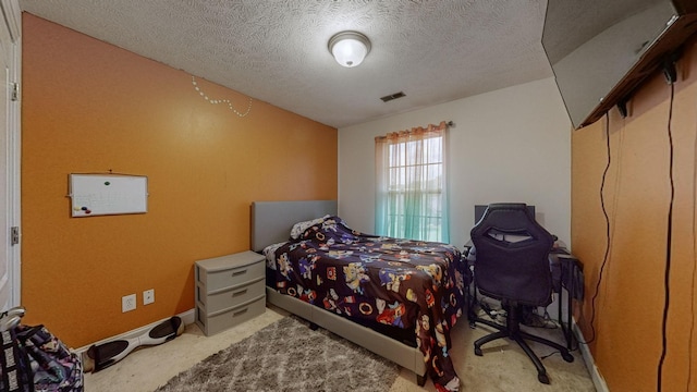 bedroom featuring carpet and a textured ceiling