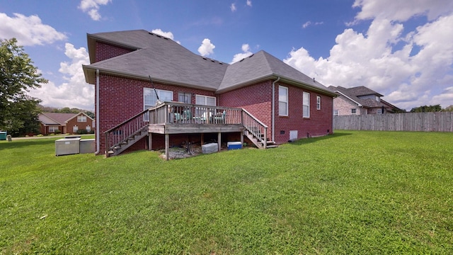 back of house featuring a wooden deck and a lawn