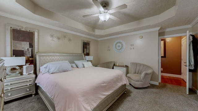 bedroom featuring crown molding, ceiling fan, carpet flooring, a tray ceiling, and a textured ceiling