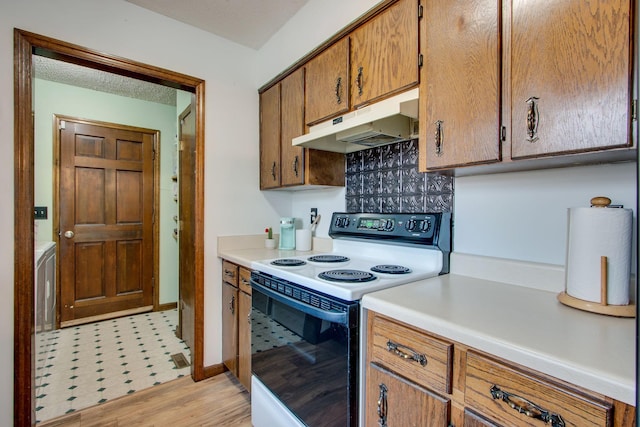 kitchen featuring range with electric cooktop, a textured ceiling, and light wood-type flooring