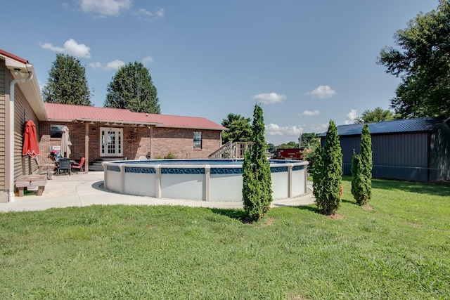 view of pool with a lawn, a patio area, and french doors