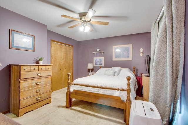 carpeted bedroom with ceiling fan and a closet